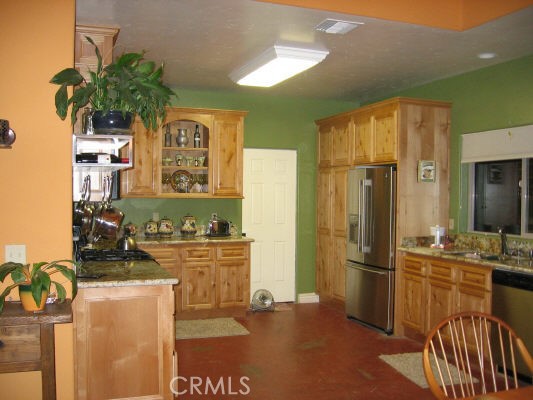 12241 Broadway Road Moorpark, CA 93021 - Photo 5 of 10 a kitchen with stainless steel appliances kitchen island granite countertop a refrigerator and a stove