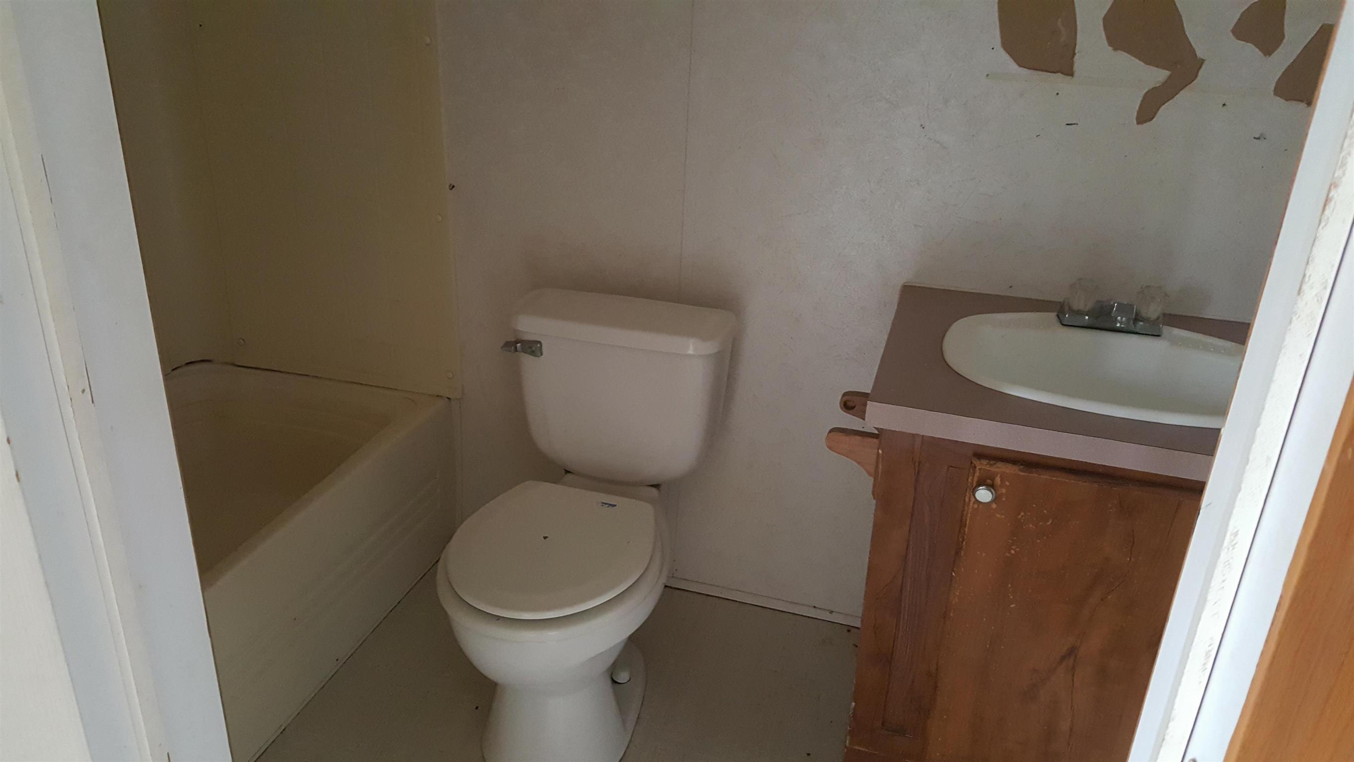 10 Zinker Road Lawrenceburg, TN 38464 - Photo 5 of 11 a white toilet sitting next to a sink and vanity