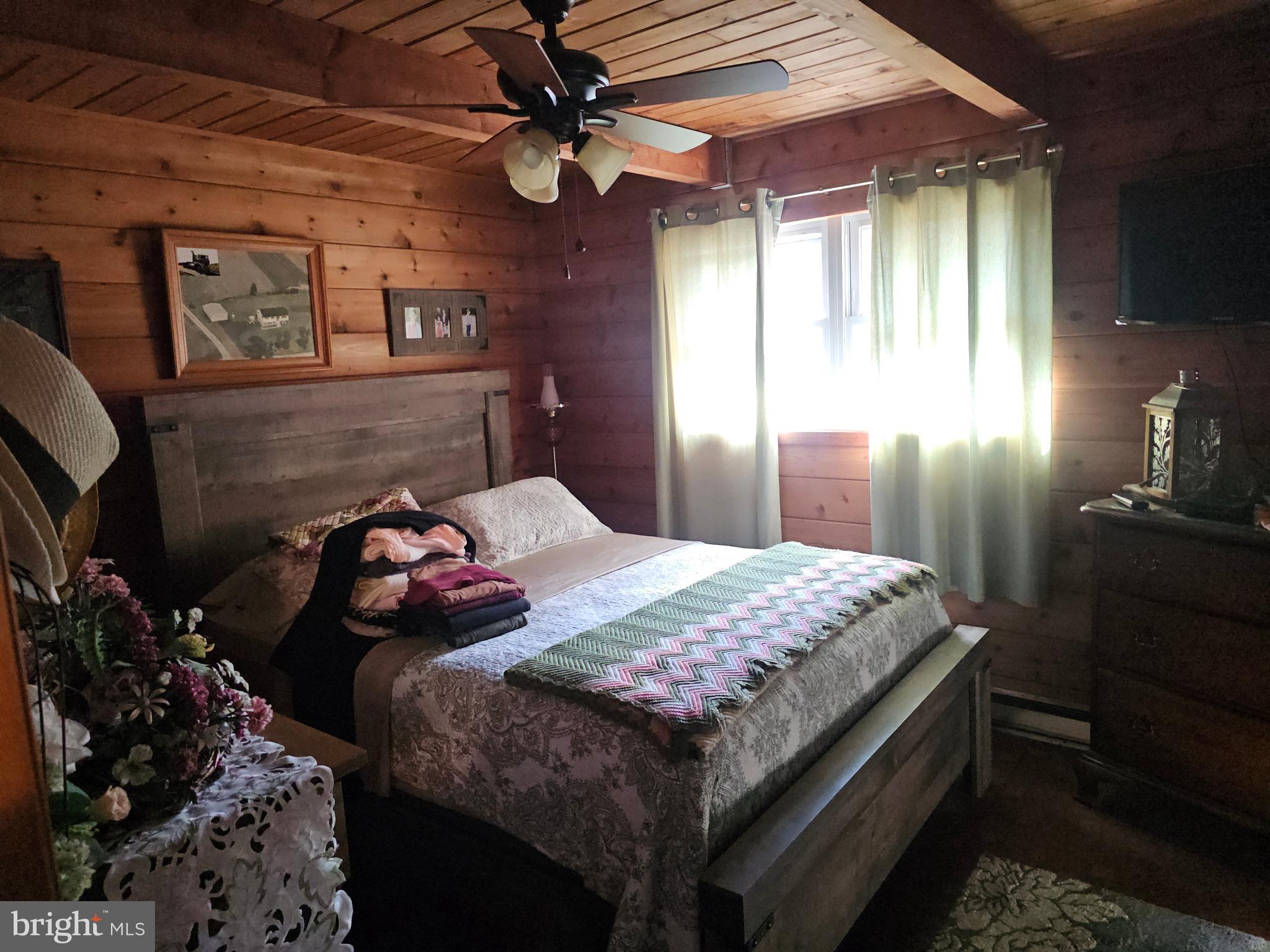 211 Martin Road Artemas, PA 17211 - Photo 30 of 38 a bedroom with a bed and a chandelier