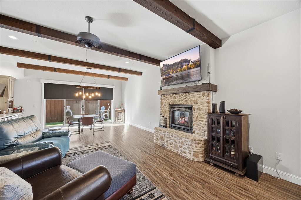 3105 Pastor Street Dallas, TX 75212 - Photo 14 of 28 Living area with a stone fireplace, Luxury Vinyl wood like floors, and beam ceiling