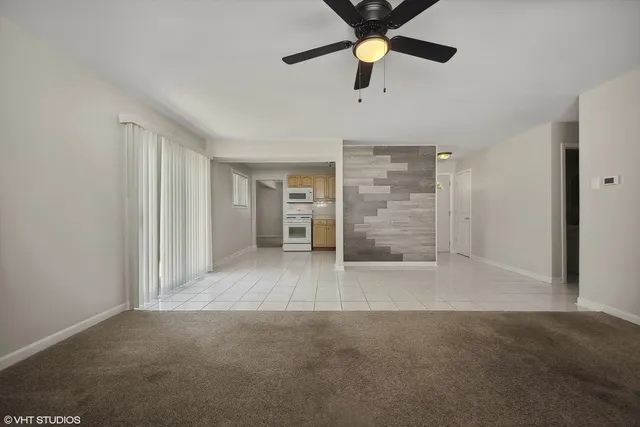 an empty room with chandelier fan