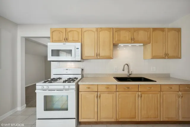 a kitchen with white cabinets and appliances