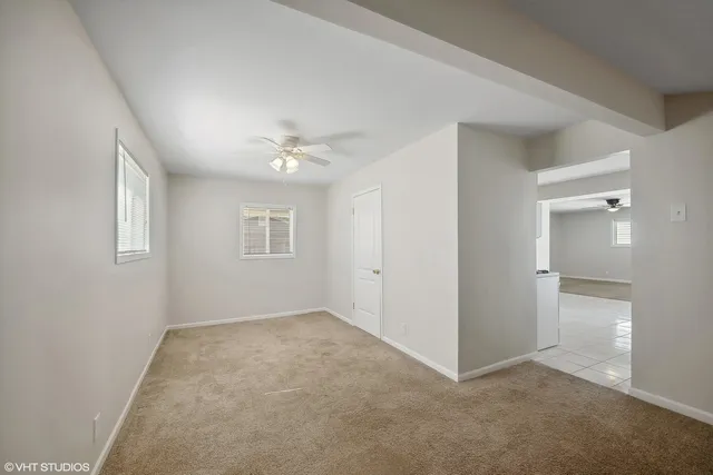 a view of an empty room with a chandelier fan