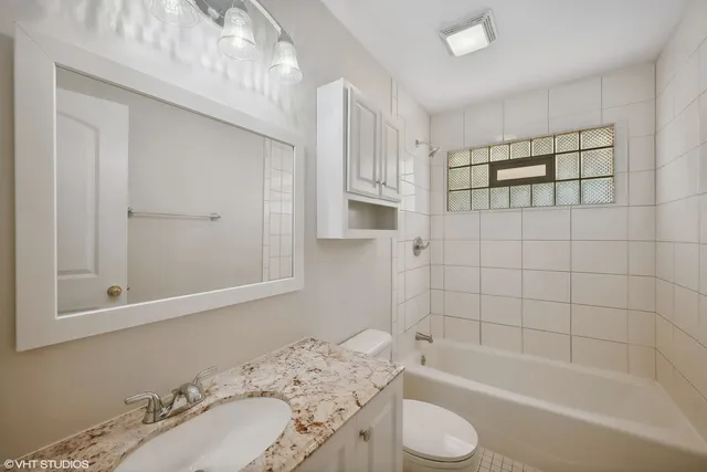 a bathroom with a granite countertop sink toilet and bathtub