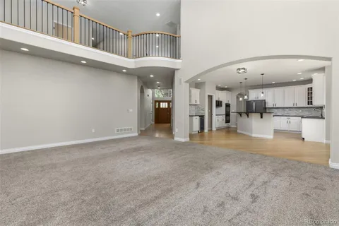 a view of an empty room and kitchen