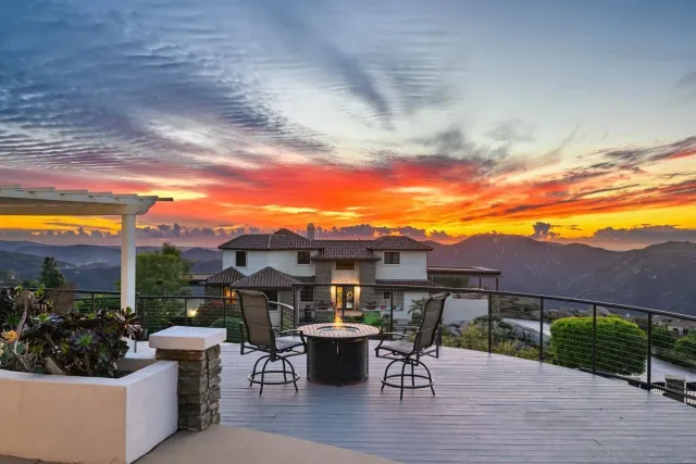 a view of a patio with couches and table and chairs under an umbrella
