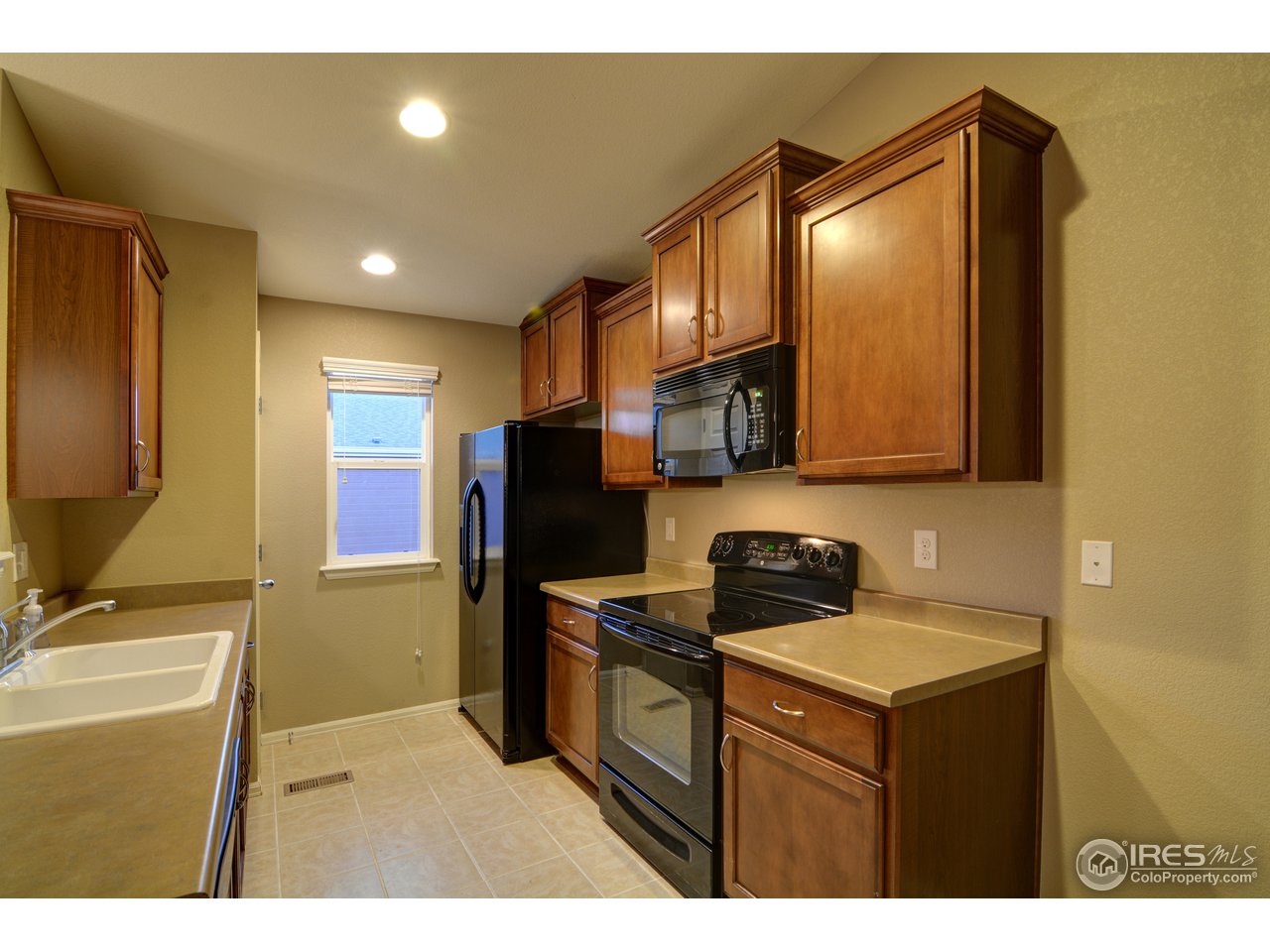 8050 Raspberry Drive Frederick, CO 80504 - Photo 5 of 17 a kitchen with stainless steel appliances a refrigerator stove and microwave