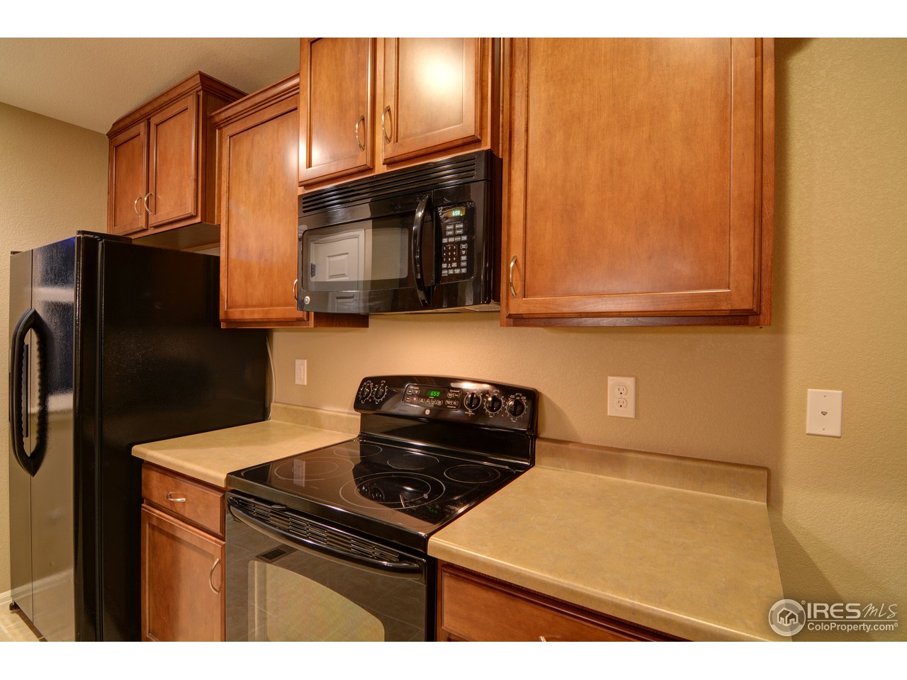8050 Raspberry Drive Frederick, CO 80504 - Photo 6 of 17 a kitchen with granite countertop cabinets and black refrigerator