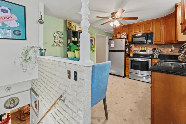 a kitchen with stainless steel appliances granite countertop a refrigerator a stove top oven a sink and dishwasher
