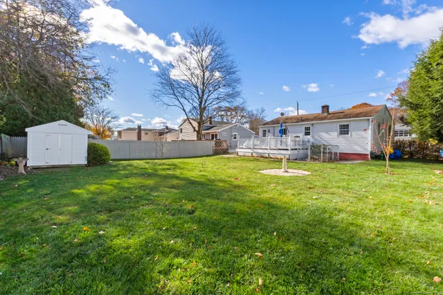 a view of a house with a big yard and a large tree
