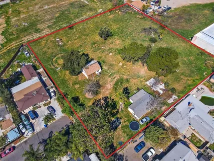 an aerial view of residential houses with outdoor space and trees