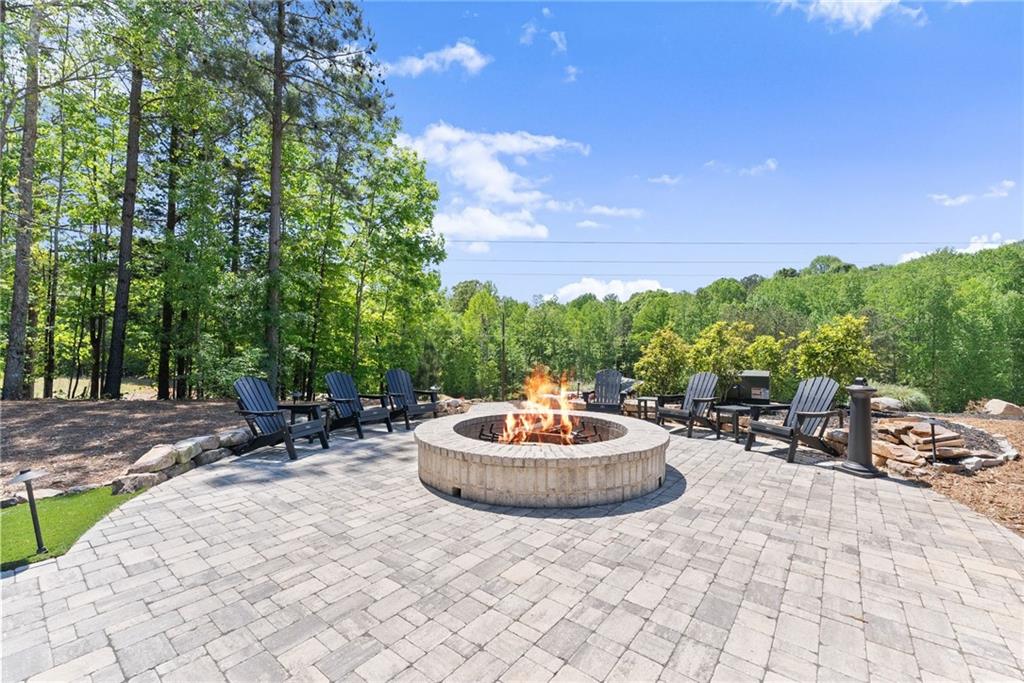3263 Tanners Mill Road Gainesville, GA 30507 - Photo 105 of 197 a backyard of a house with a fountain and a fire pit