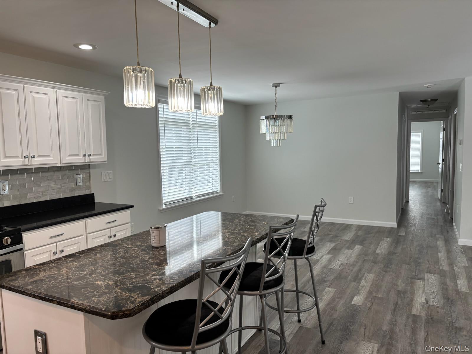 1661 Old Country Road, Unit 539 Riverhead, NY 11901 - Photo 8 of 26 a kitchen with granite countertop a table and chairs in it