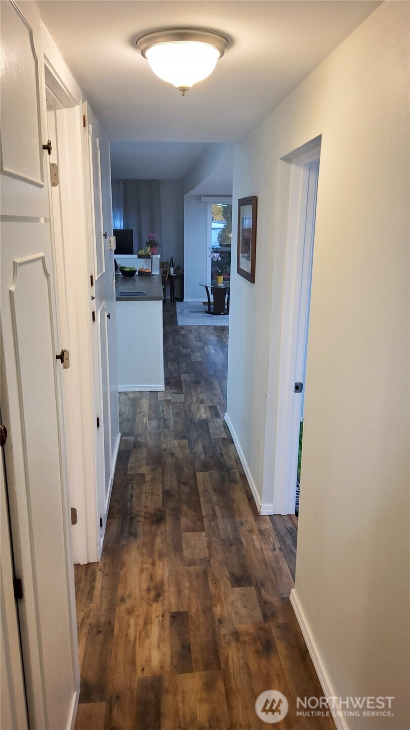 13320 Highway 99, Unit 34 Everett, WA 98204 - Photo 17 of 23 a view of a kitchen with wooden floor and a refrigerator