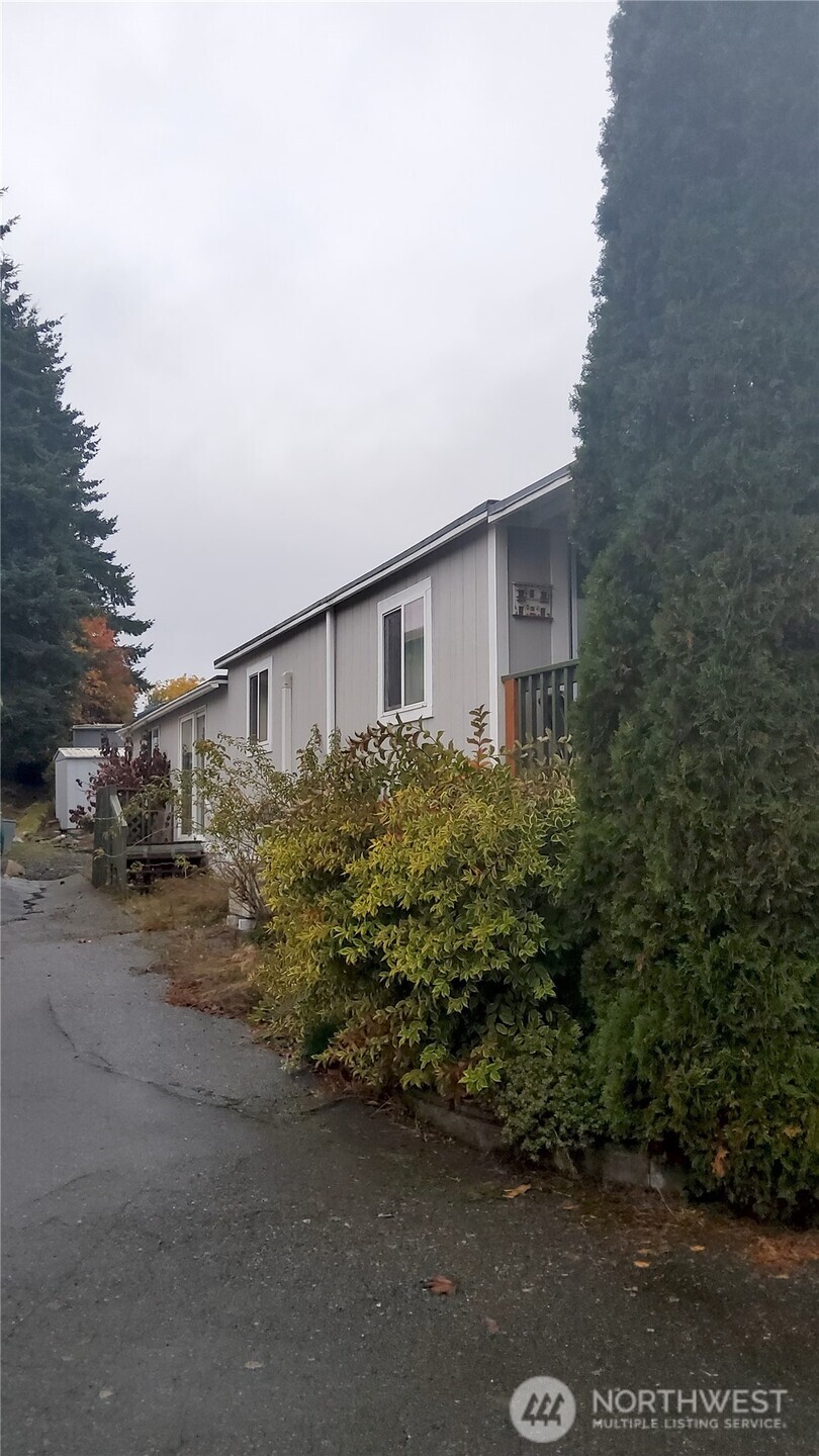 13320 Highway 99, Unit 34 Everett, WA 98204 - Photo 21 of 23 a house with trees in front of it