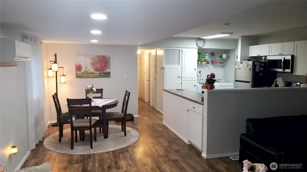 a kitchen with stainless steel appliances a dining table chairs and a refrigerator