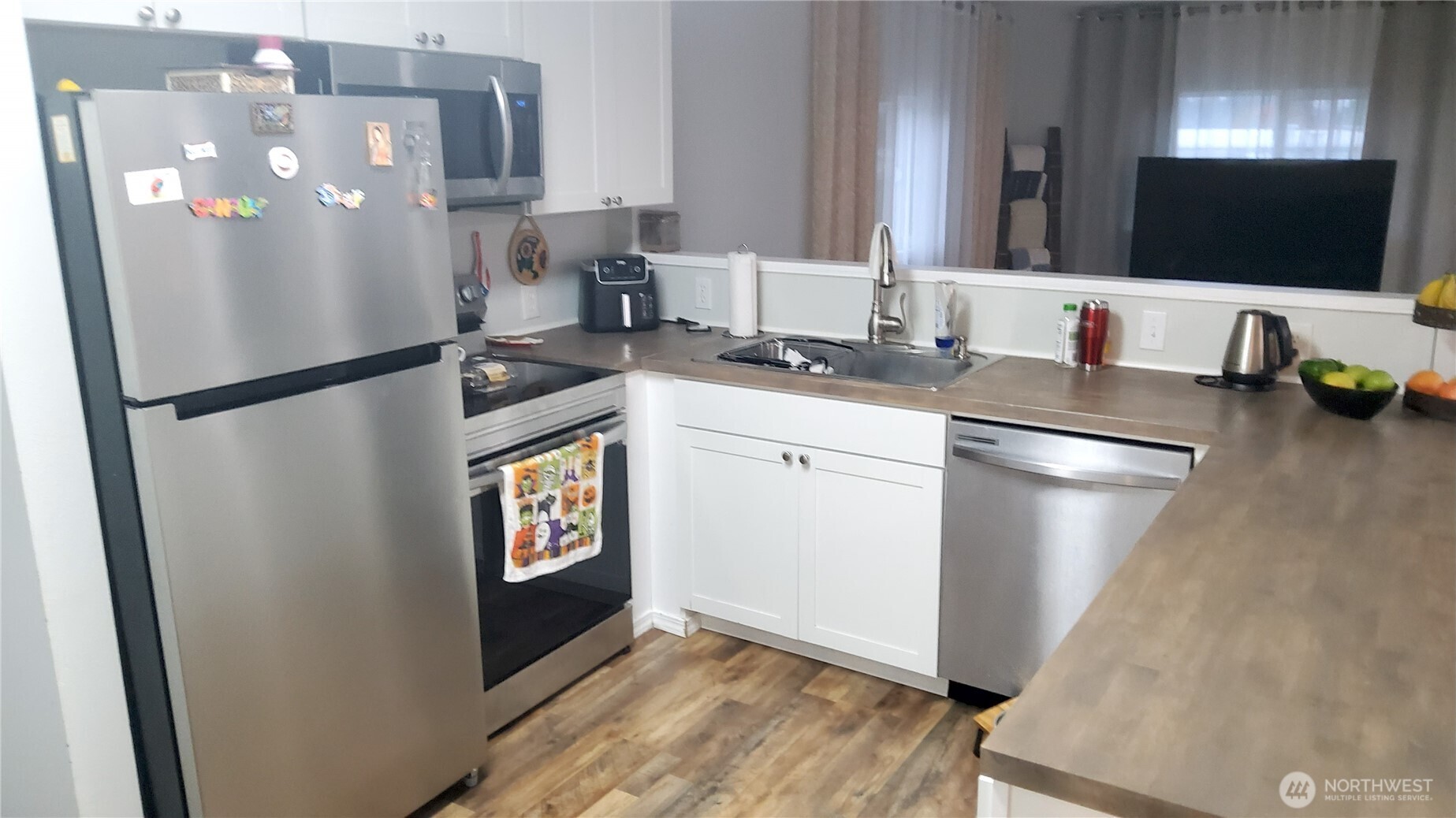 13320 Highway 99, Unit 34 Everett, WA 98204 - Photo 8 of 23 a kitchen with stainless steel appliances a refrigerator a sink a stove and island