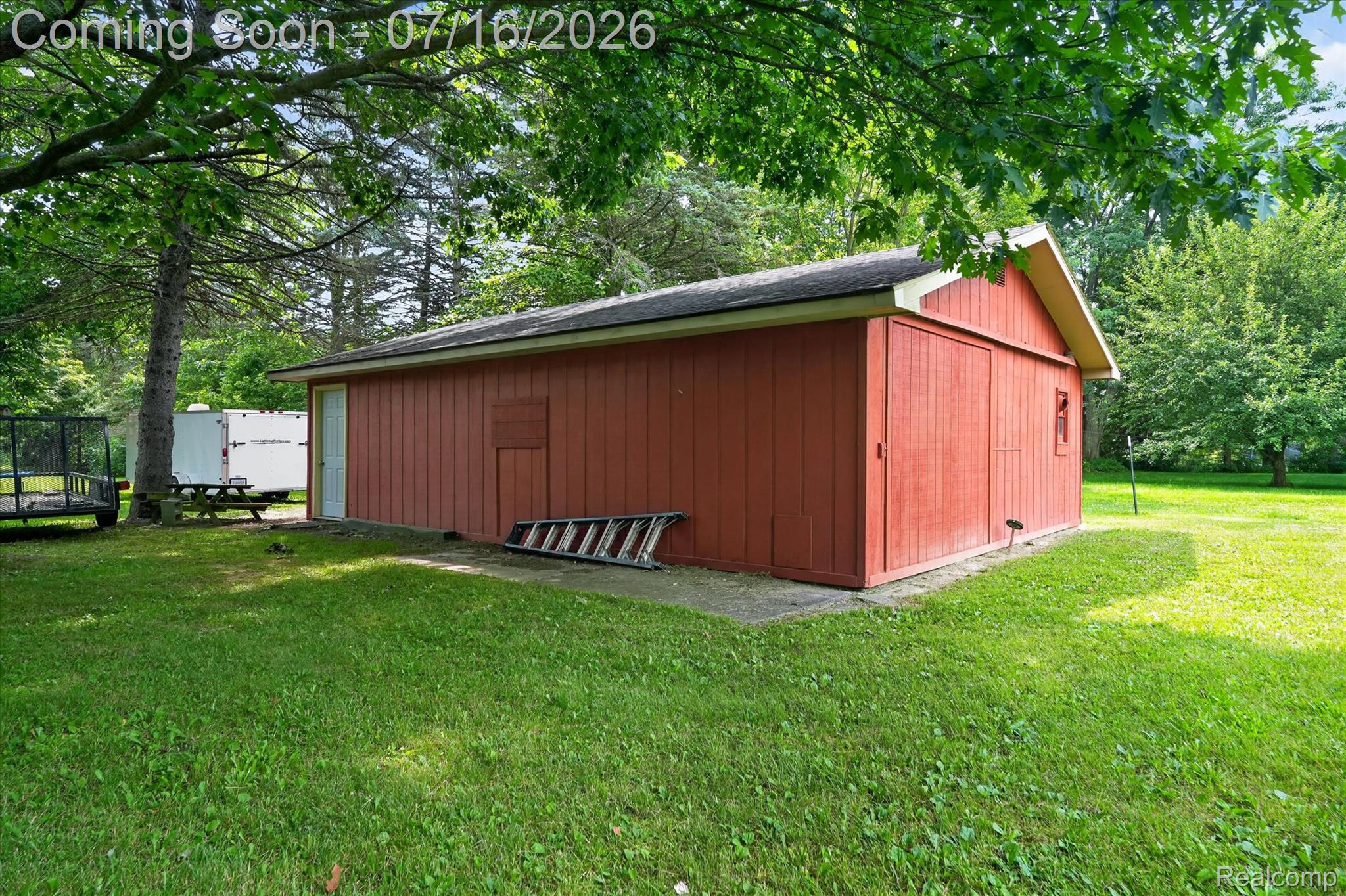 11210 Linden Road Linden, MI 48451 - Photo 31 of 61 Detached outbuilding with red vertical siding, a dark shingle roof, and a concrete foundation