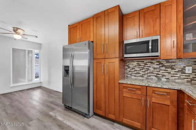 a kitchen with granite countertop stainless steel appliances a refrigerator and cabinets