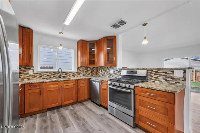 a kitchen with stainless steel appliances granite countertop a stove and a sink