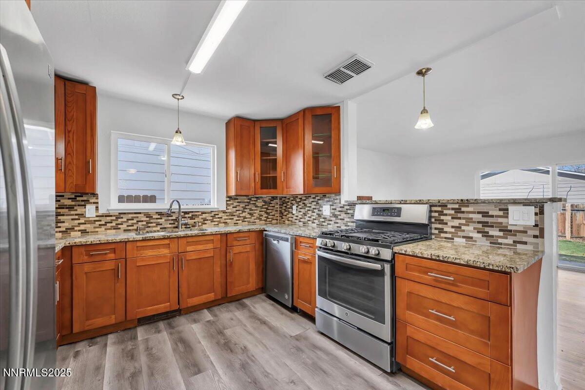 2801 Kings Row Reno, NV 89503 - Photo 12 of 32 a kitchen with stainless steel appliances granite countertop a stove and a sink