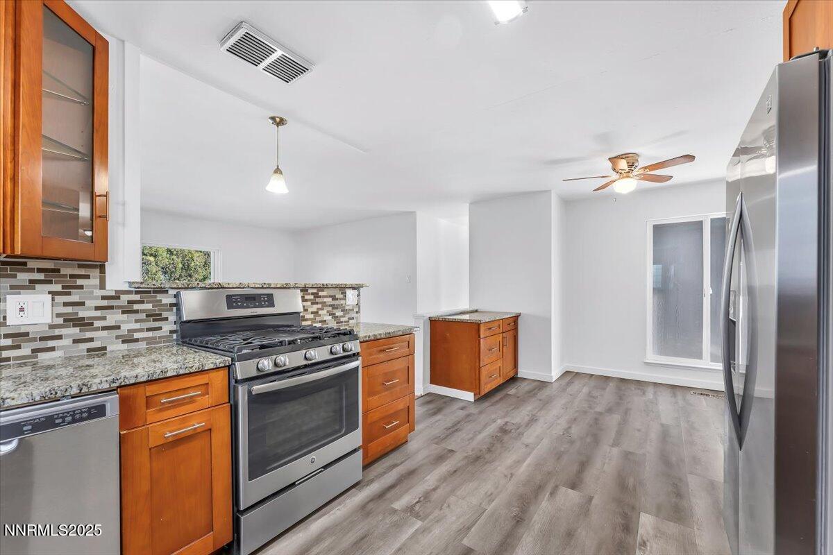 2801 Kings Row Reno, NV 89503 - Photo 13 of 32 a kitchen with stainless steel appliances granite countertop a stove cabinets and wooden floor