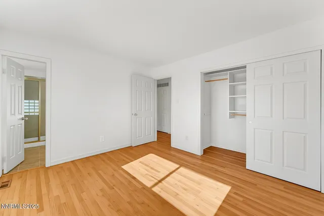 a view of empty room with wooden floor