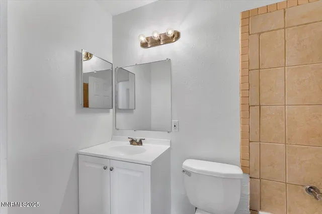 a bathroom with a toilet a sink and mirror