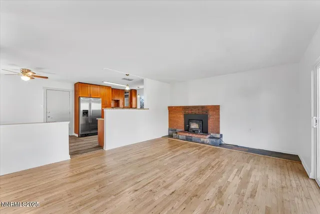 a view of a livingroom with wooden floor and a fireplace