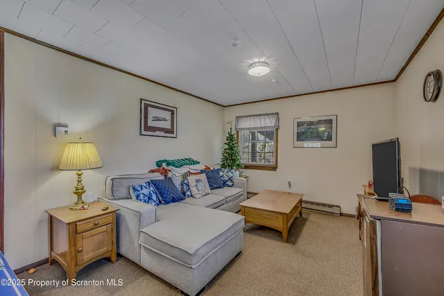 a living room with furniture a lamp and a flat screen tv