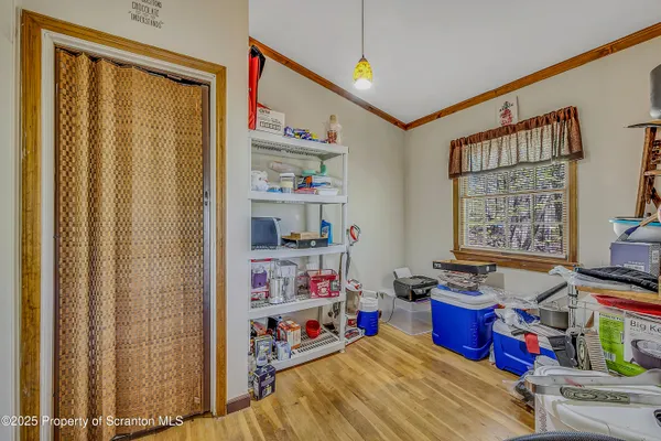 a storage room with stainless steel appliances wooden floor and window