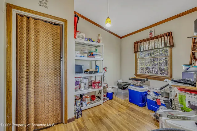 a storage room with stainless steel appliances wooden floor and window