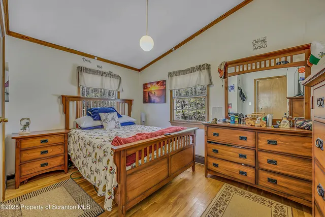 a bedroom with a bed and a large mirror on the dresser