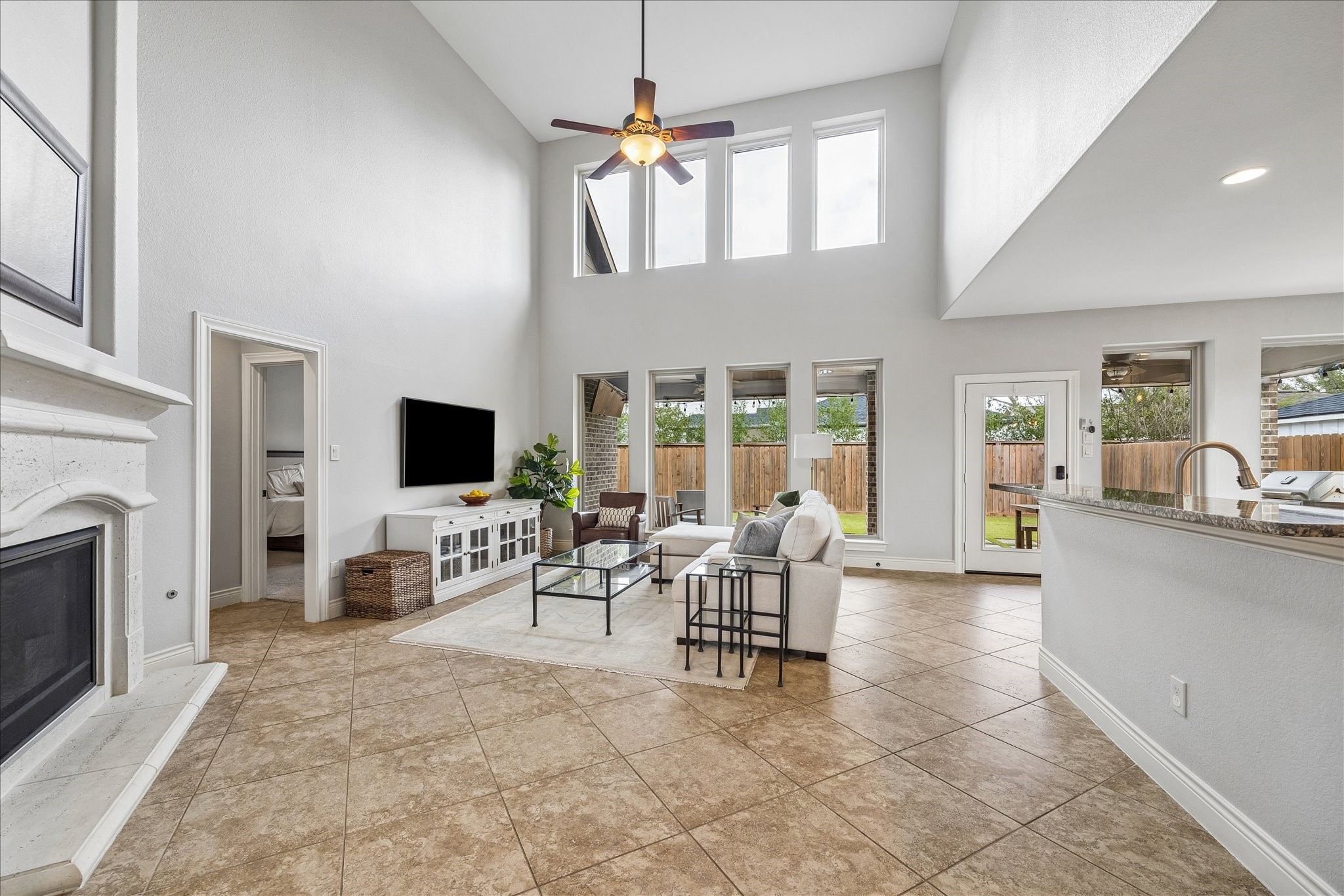 1616 Hewitt Drive Houston, TX 77018 - Photo 6 of 44 Living room features soaring ceilings and a gas fireplace framed by stone and a wood mantel. A wall of windows connects the interior living spaces to the backyard.