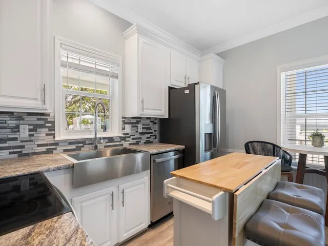 a kitchen with a refrigerator a sink a stove and cabinets