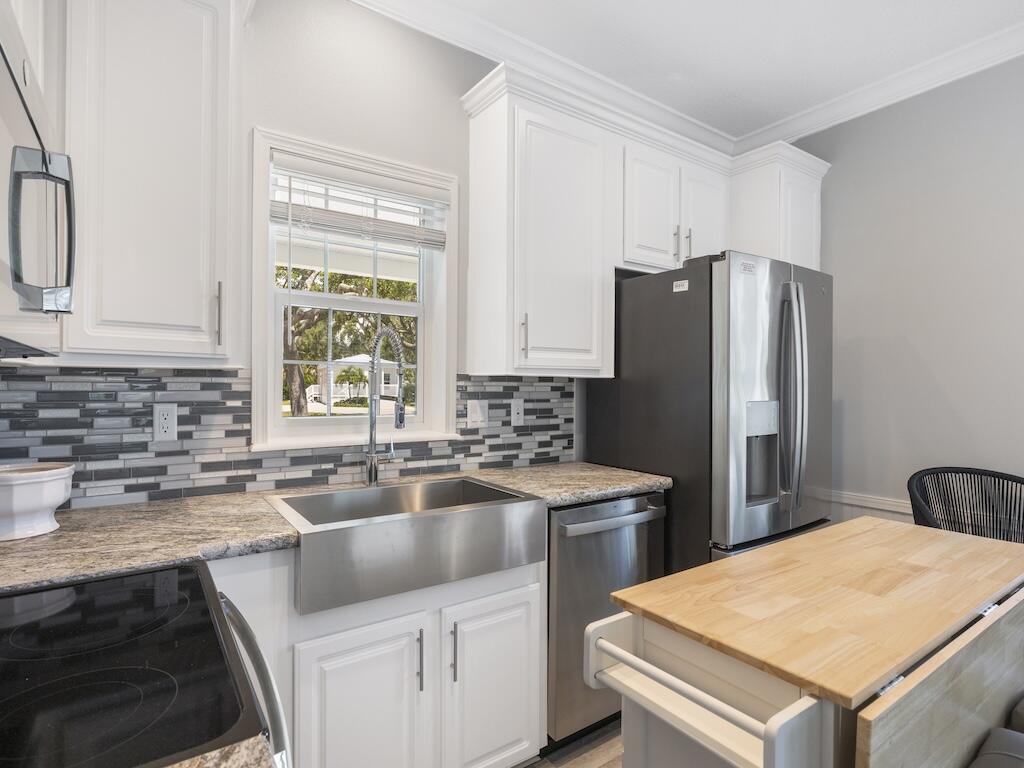12939 North Indian River Drive, Unit 1 Sebastian, FL 32958 - Photo 12 of 46 a kitchen that has a sink a stove and a refrigerator
