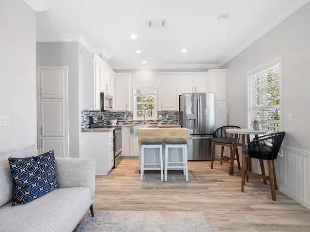 a living room with stainless steel appliances kitchen island granite countertop furniture and a couch