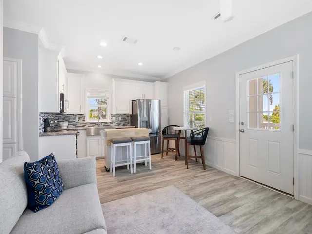 a living room with lots of furniture and kitchen view