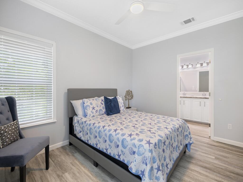 12939 North Indian River Drive, Unit 1 Sebastian, FL 32958 - Photo 20 of 46 a large bed sitting in a bedroom next to a window and chair