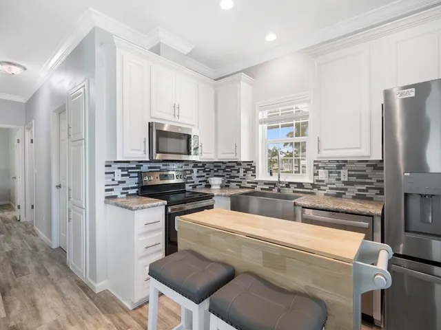 a kitchen with a refrigerator and a stove top oven