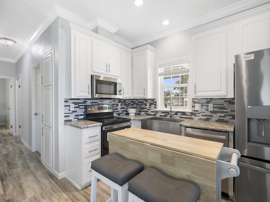 12939 North Indian River Drive, Unit 1 Sebastian, FL 32958 - Photo 7 of 46 a kitchen with a refrigerator and a stove top oven