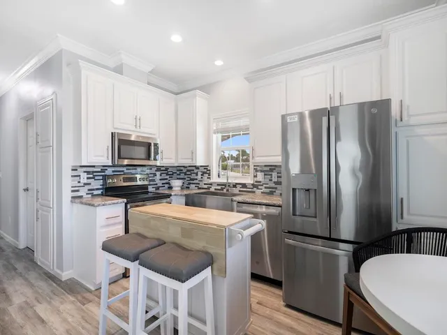 a kitchen with white cabinets stainless steel appliances and sink