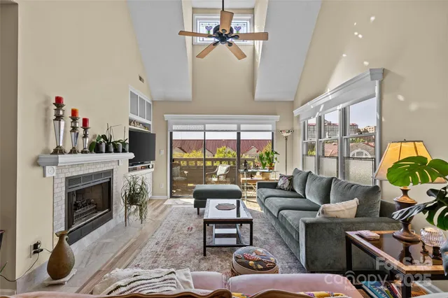 a living room with furniture a fireplace and a chandelier