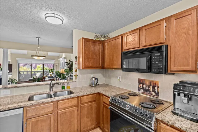 a kitchen with stainless steel appliances granite countertop a stove sink and cabinets