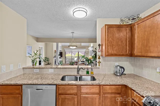 a kitchen with granite countertop a sink a counter space appliances and cabinets