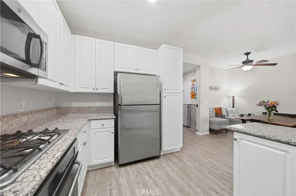 a kitchen with a refrigerator stove and white cabinets