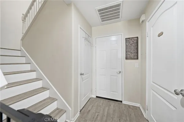 a view of a hallway with wooden floor and entryway