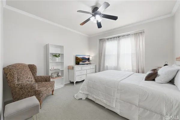 a bedroom with furniture and a large window