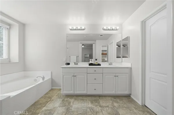 a spacious bathroom with a tub sink and mirror