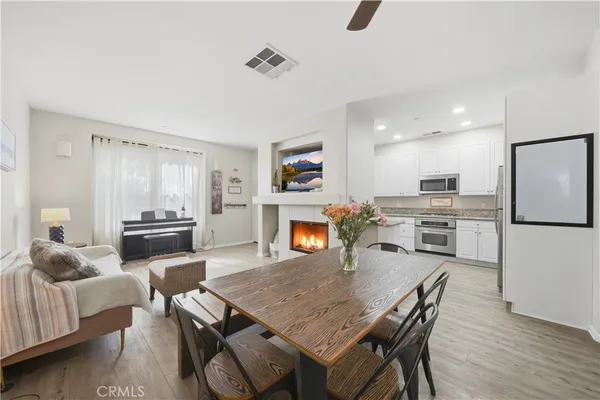 a kitchen with a table chairs refrigerator and microwave